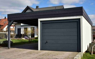 Kombination von Einzelgarage mit grauem Garagentor und eiem Carport