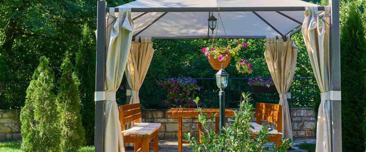 Pavillon mit Seitenteilen und Dach aus Stoff als Schattenspender für gemütliche Sitzgruppe