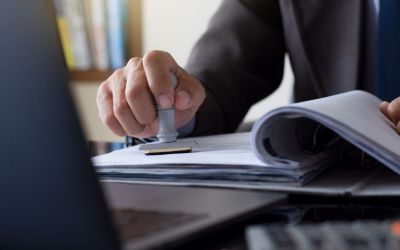 Mitarbeiter eines Veterinäramts stempelt ein Dokument