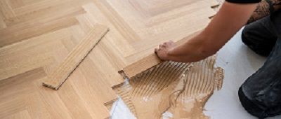 Parkettleger verlegt Massivparkett im Fischgrätmuster