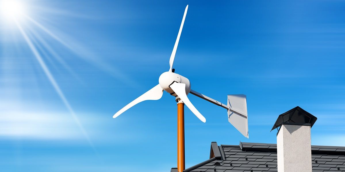 Hausdach mit Kleinwindkraftanlage bei strahlendem Sonnenschein